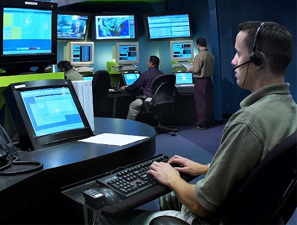 三名菲律宾bg视讯官网网络运营员工在电脑和电视显示器上监控数据